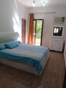 um quarto com uma cama com um edredão azul e uma janela em الريف الاوروبي em El-Qaṭṭa