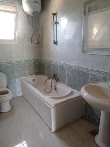 a bathroom with a tub and a toilet and a sink at الريف الاوروبي in Al Qaţā