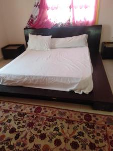 a bedroom with a bed with a white comforter and a rug at الريف الاوروبي in Al Qaţā