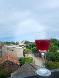 a glass of red wine sitting on top of a balcony at La Reserva de UBA in El Socorro