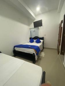 een slaapkamer met 2 bedden en een flatscreen-tv bij La Reserva de UBA in El Socorro