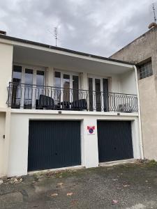 uma casa branca com duas portas de garagem e uma varanda em Appartement neuf et spacieux, centre ville, garage em Tournon-sur-Rhône