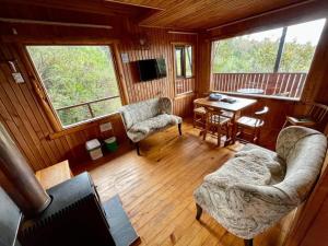 una sala de estar con sofá y sillas en una cabaña en Cabañas Kalfvgen, en Valdivia