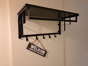 een welkomstbord hangt aan een muur bij 't Klèène Genot in Hollum +8 foto's