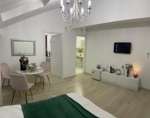 um quarto branco com uma cama, uma mesa e uma televisão em Vila Zoe BucharestAirport&Therme&Parking Otopeni em Otopeni