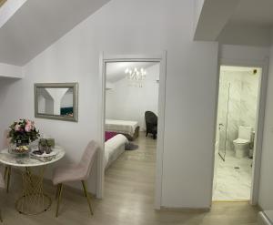 a white room with a table and a bedroom at Vila Zoe BucharestAirport&Therme&Parking Otopeni in Otopeni