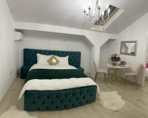 sypialnia z niebieskim łóżkiem i stołem z krzesłami w obiekcie Vila Zoe BucharestAirport&Therme&Parking Otopeni w mieście Otopeni