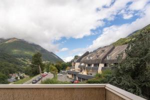 a view from a balcony of a town with mountains at L'horizon studio in Cauterets