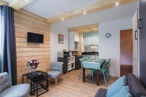 a living room and kitchen with a table and chairs at L'horizon studio in Cauterets +6 photos