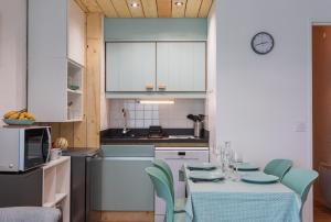 a kitchen with a table and chairs in a kitchen at L'horizon studio in Cauterets