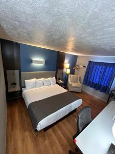 Una habitación de hotel con una cama grande y un escritorio. en Rodeway Inn, en Emporia