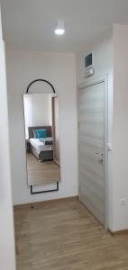 um quarto com uma cama e um espelho na parede em Apartmani Stara Skola 