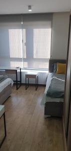 a room with two beds and a table and two windows at Apartmani Stara Skola 