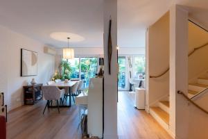 uma sala de estar e de jantar com uma escada e uma mesa de jantar em Maison avec piscine - Vincennes em Vincennes