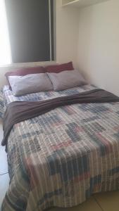 uma cama com um cobertor num quarto em Apartamento flat em condomínio club em Aracaju
