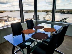 mesa de comedor con sillas y vistas al río en Waterfront 1 Bedroom Skyscraper Suite - 18th Floor - Free Garage Parking en Helsinki
