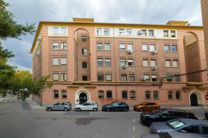 a large brick building with cars parked in a parking lot at TrendyHomes Granada - moderno apartamento a 15 minutos del centro in Granada