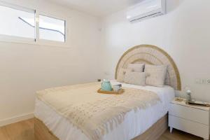 a white bedroom with a large bed and a window at Sea light in Puerto del Carmen