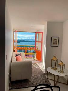 a living room with a couch and a view of the ocean at Apartamento 306 - Vista a la Represa - 1 Habitación - Rentas Cortas Gerencial in Guatapé