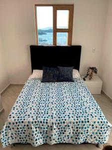 a bedroom with a large bed with a large window at Apartamento 306 - Vista a la Represa - 1 Habitación - Rentas Cortas Gerencial in Guatapé