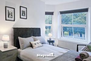 sypialnia z łóżkiem i 2 oknami w obiekcie Astonishing 6 Bedroom 4baths House w Manchesterze