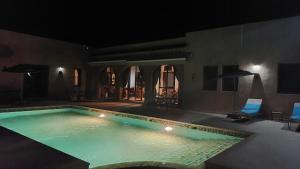 a swimming pool in a house at night at Dar Chenguiti in Taroudant