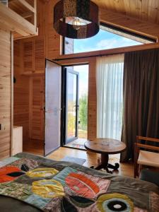 a bedroom with a bed and a table and a large window at Skijis Sakhli in Zenobani