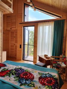 a bedroom with a bed and a large window at Skijis Sakhli in Zenobani