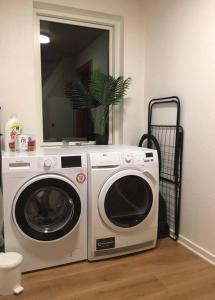 a washing machine in a room with a mirror at House Living Billund in Billund