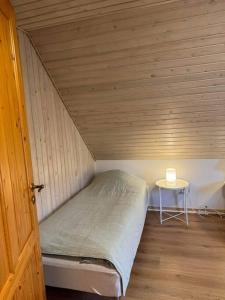 uma pequena cama num pequeno quarto com uma mesa em House Living Billund em Billund mais 11 fotografias