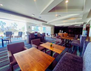 a dining room with wooden tables and chairs at La Quinta by Wyndham Aguascalientes in Aguascalientes