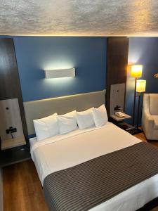 Rodeway Inn في إمبوريا: غرفة نوم بسرير كبير بجدار ازرق