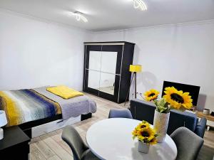 - une chambre avec un lit et une table avec des tournesols dans l'établissement Concept Urban, à Mediaş