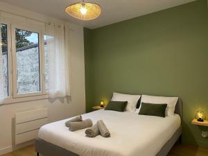 Schlafzimmer mit einem großen weißen Bett und einem Fenster in der Unterkunft Appartement neuf et spacieux, centre ville, garage in Tournon-sur-Rhône