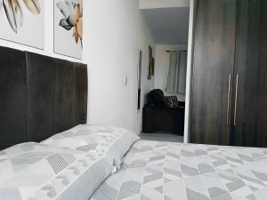 um quarto com uma cama e um armário de madeira em Apartamento Completo A25 Flat Centro em Mogi das Cruzes