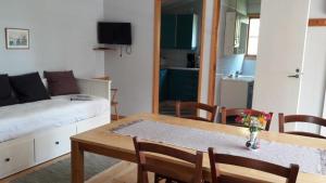a living room with a dining room table and a bed at Mellangårds stugor - Första stugan in Föglö