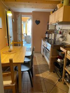 a kitchen with a wooden table and a table and a table and a dining room at Gemütliche Hof Wohnung in St Martin mit Sauna in Sankt Martin +2 photos