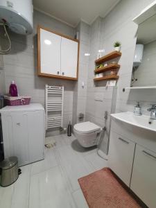 a white bathroom with a toilet and a sink at Apartment Noa in Tuzla