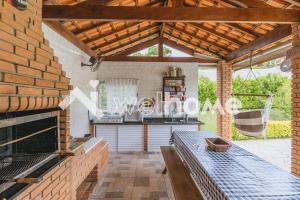 uma cozinha com uma mesa e um grelhador numa casa em Casa com ampla área verde e piscina em Itupeva em Itupeva