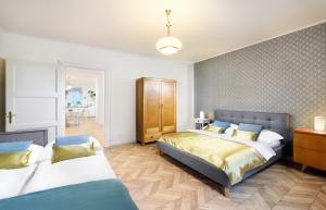 a bedroom with two beds and a dining room at Bonton Apartments in Kežmarok