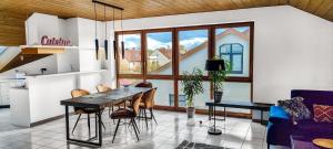 a kitchen with a table and chairs in a room at Stylish loft with balcony, quiet and spacious in Unterschleißheim