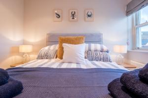 Un dormitorio con una cama grande con dos lámparas. en Beautiful Central Tenby Apartment with free parking, en Tenby