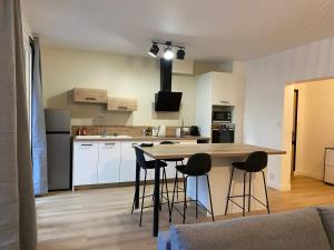 eine Küche mit einem Tisch und Stühlen in einem Zimmer in der Unterkunft Appartement neuf et spacieux, centre ville, garage in Tournon-sur-Rhône