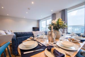 Un comedor con una mesa con platos y vasos. en Beautiful Central Tenby Apartment with free parking, en Tenby