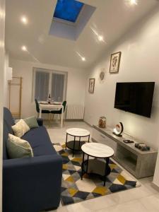 a living room with a blue couch and a tv at Maison avec Jacuzzi - Louvres proche Roissy CDG - Paris in Louvres