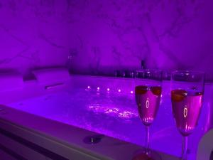 LouvresにあるMaison avec Jacuzzi - Louvres proche Roissy CDG - Parisの紫色の客室で、バスタブ(ワイングラス2杯付)が備わります。