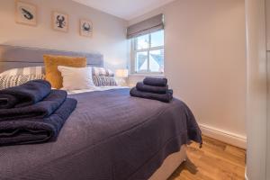 Un dormitorio con una cama con mantas azules encima. en Beautiful Central Tenby Apartment with free parking, en Tenby 10 fotos más