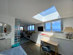 un soggiorno con lucernario e una camera con scrivania di Villa Oasis La Paz - Acaymo Loft - ADULTS ONLY - a Puerto de la Cruz