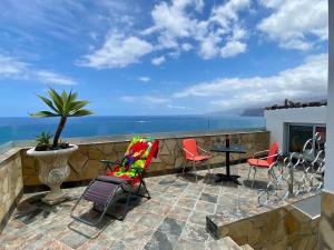 un patio con sedie, tavolo e vista sull'oceano di Villa Oasis La Paz - Acaymo Loft - ADULTS ONLY - a Puerto de la Cruz