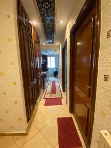 a hallway with a door and two red rugs at la paix in Ifrane